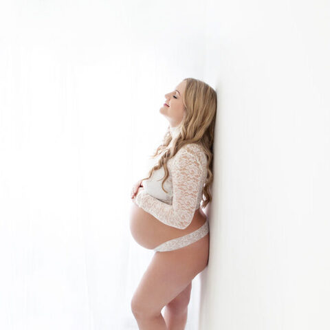 maternity photography standing by the wall